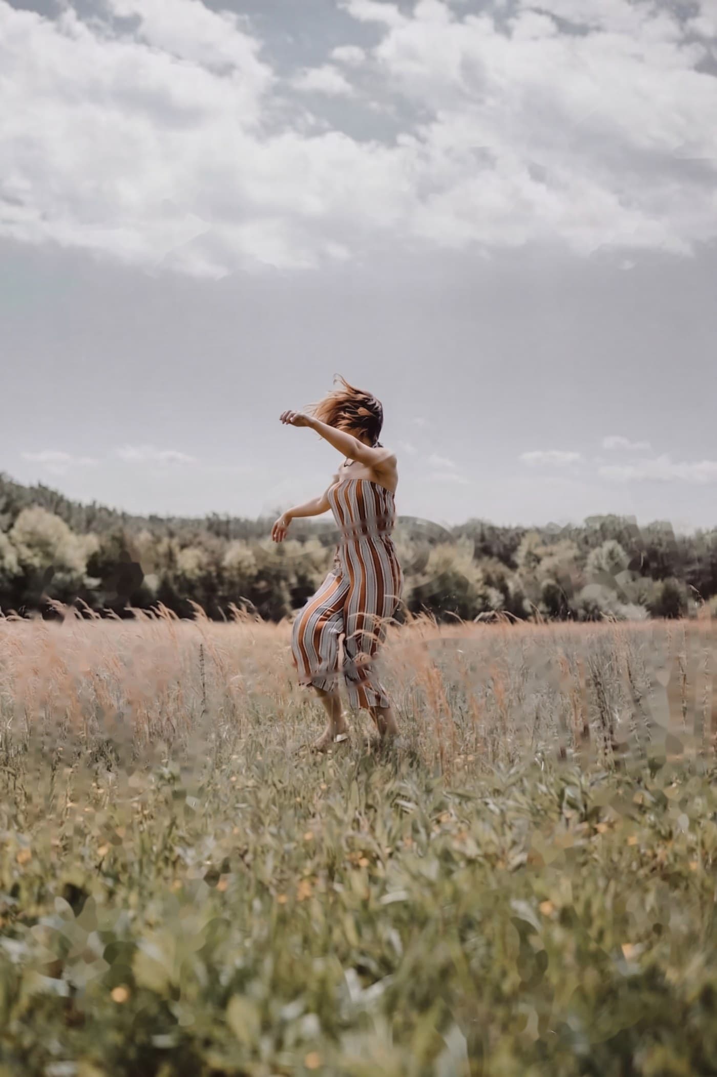 A figure dancing in a sunlit field with hand-drawn doodles fading in around her